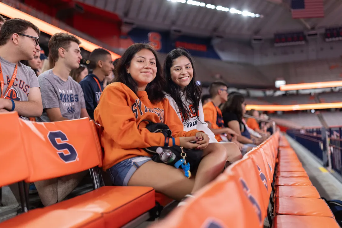 People sitting in a stadium and smiling.