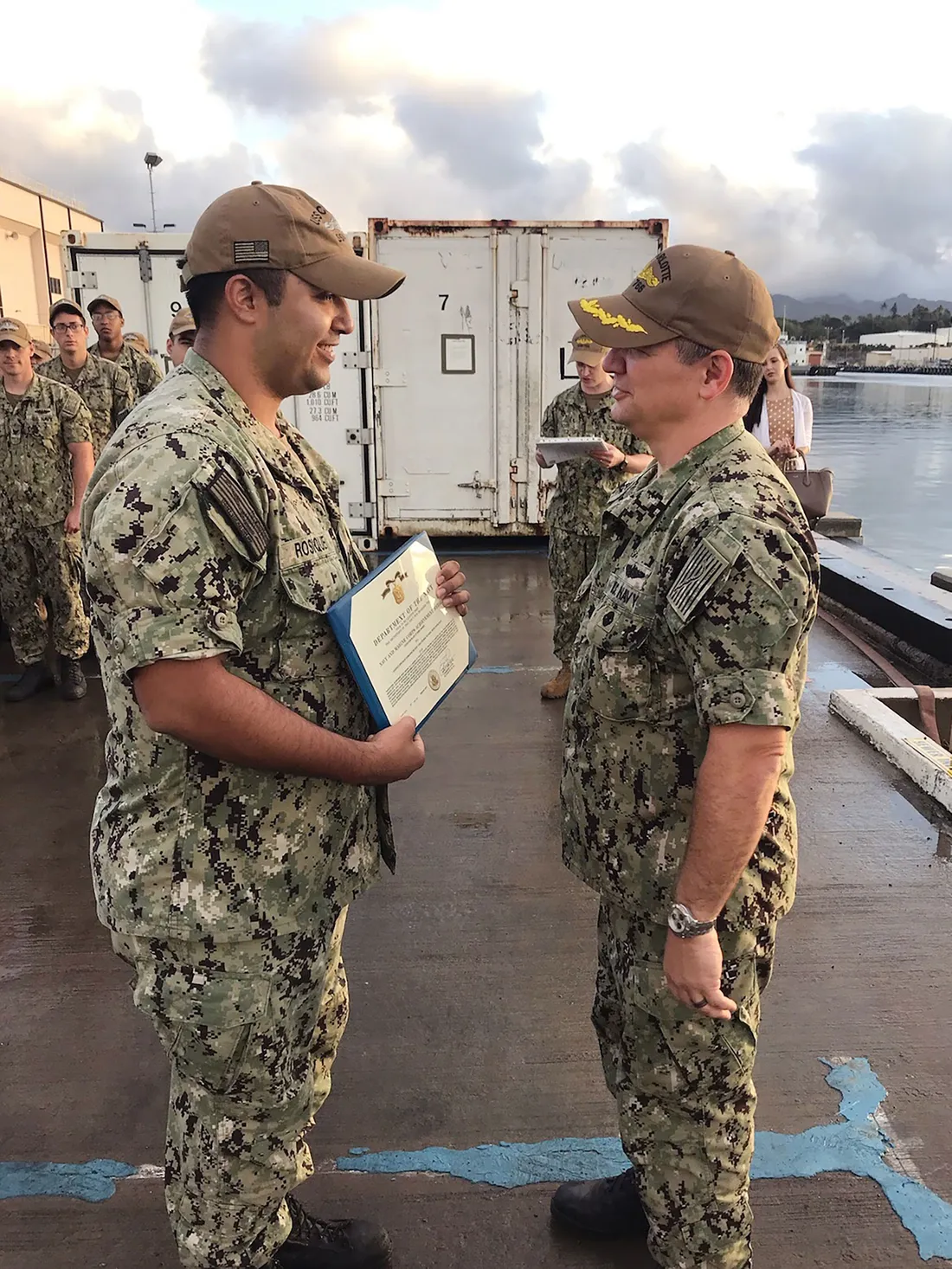 Two people in army uniform talking.